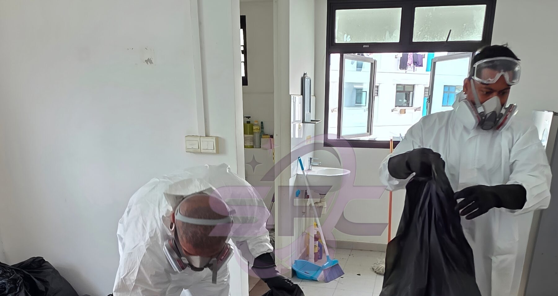Two SFC technicians in full protective coveralls, respirators and goggles bagging waste on a Singapore job