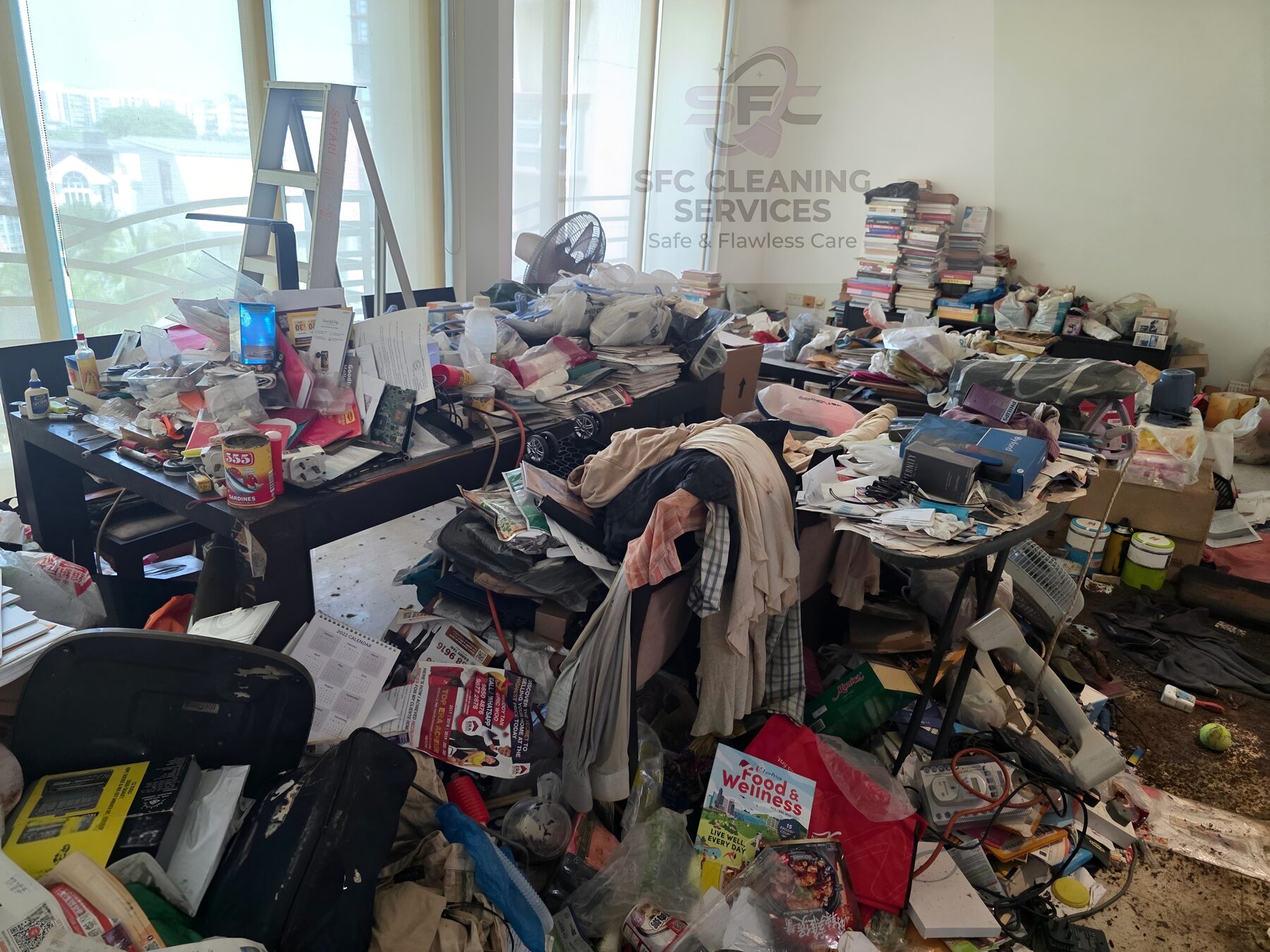 A hoarded Singapore apartment room photographed by SFC before clearance, floor and surfaces buried in belongings