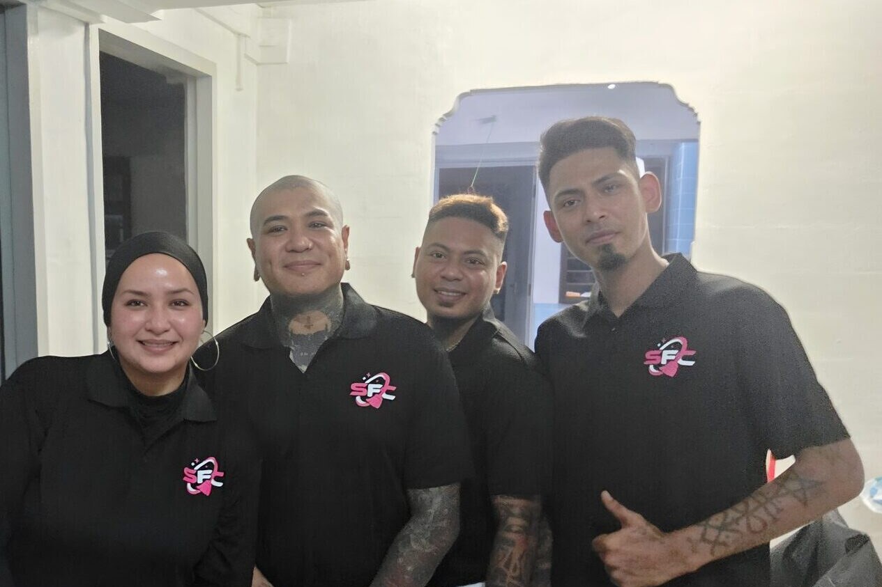 Four members of the SFC team, three men and a woman in a black headscarf, standing together in matching black polo shirts with the SFC logo on the chest.
